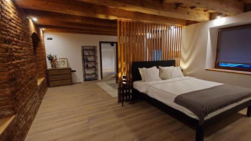 a bedroom with a large bed and a brick wall at ALBERT RESIDENCE Brasov in Braşov