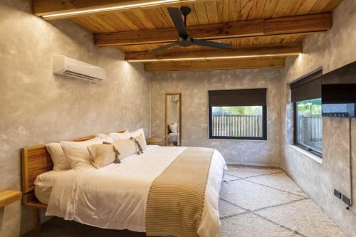 a bedroom with a bed and a ceiling fan at Seabird - Villa 12 in Placencia Village