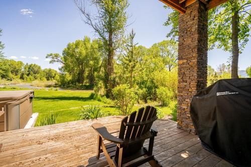 a rocking chair on a deck with a view of a yard at Beautiful Driggs Townhome with Views and Hot Tub in Driggs