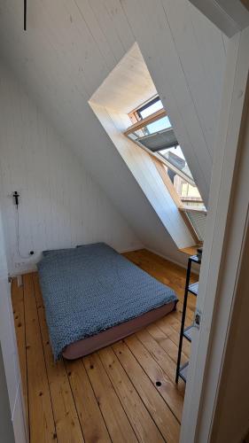 a room with a bed in the middle of a attic at Svencele K12 in Svencelė