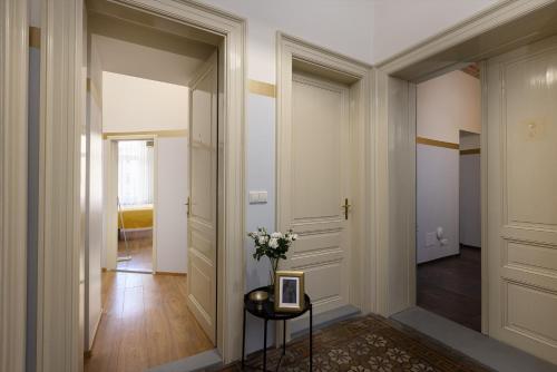 a hallway with a vase of flowers on a table at Salvatore Prague Rooms in Prague