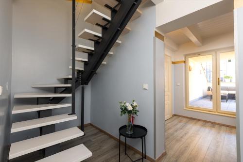 a staircase in a room with a vase of flowers on a table at Salvatore Prague Rooms in Prague
