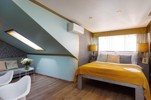 a bedroom with a large bed with a yellow blanket at Salvatore Prague Rooms in Prague