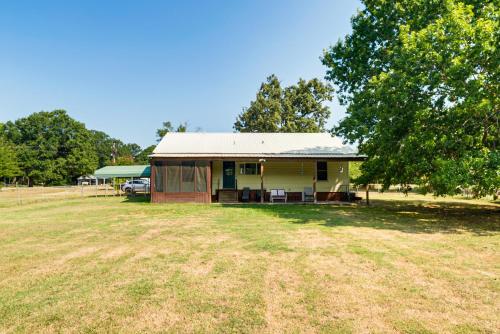 a small yellow house with a tree and a field at Screened Patio and Fire Pit Peaceful Marshall Home in Marshall