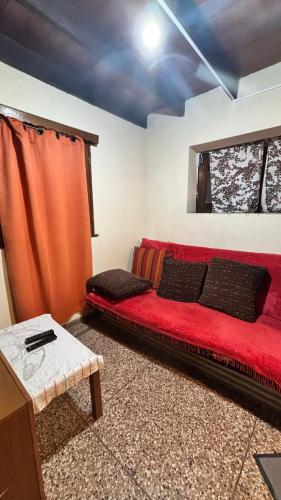 a living room with a red couch in a room at CAMIGIGA Alquiler en Barra de Chuy, Uruguay in Barra del Chuy