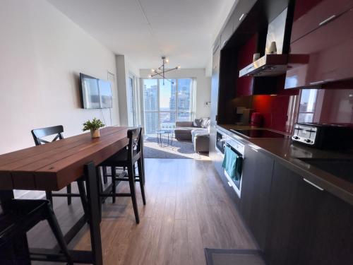 a kitchen and dining room with a wooden table in a room at Comfy Front Wellington Suites CN Tower Rogers Centre & Free Parking in Toronto