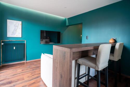 a dining room with blue walls and a wooden table at Suite Zen - Calme et Lumière - 2 lits 160 cm - Parking privé résidence in Sélestat