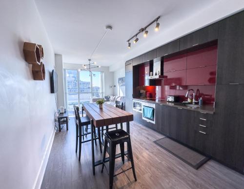 a kitchen and dining room with a wooden table and chairs at Comfy Front Wellington Suites CN Tower Rogers Centre & Free Parking in Toronto