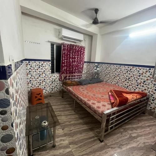 a bedroom with a bed and a table in it at Tara Laxmi bhavan in Tarapith