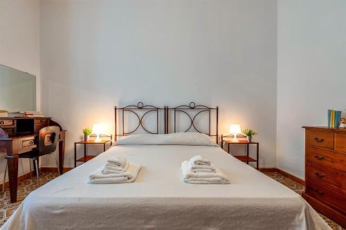 een slaapkamer met een bed met handdoeken erop bij Mary's House- Alghero in Alghero