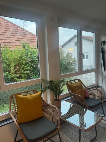two chairs and a table in a room with windows at Landhaus mit Garten in Neutal