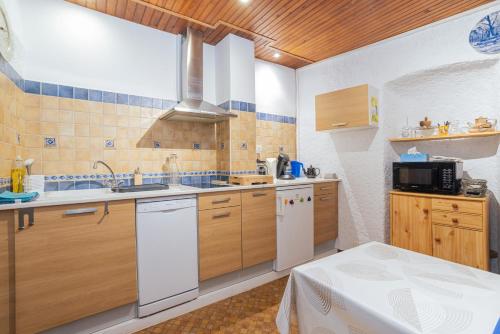 a kitchen with wooden cabinets and a white refrigerator at Au Petit Paris, Centre de Céret in Céret