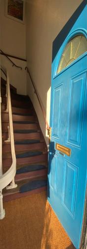 Maison Pauline في Saint-André: باب أزرق في غرفة بها درج