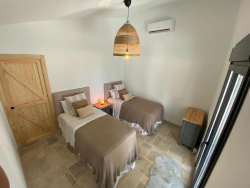 a small room with two beds and a door at Finca Celia Competa in Cómpeta