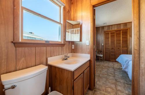 a bathroom with a sink and a toilet and a window at Laughing Place - Southern Shores, 175 Ft to Beach, Pool Table, Pets OK, Flex Stays in Southern Shores