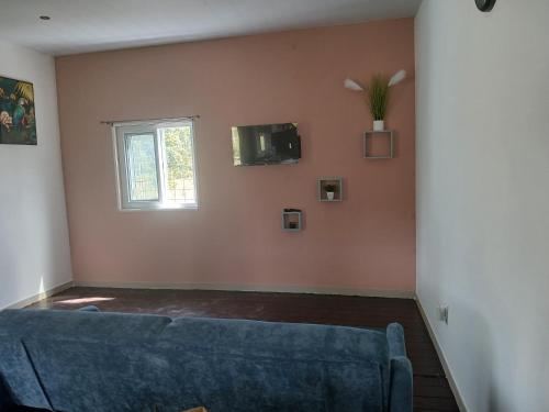 a living room with a blue couch and a window at Magnifique Carbet in Roura