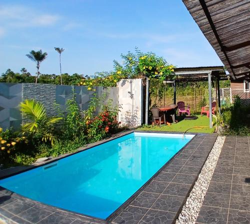 a swimming pool in the backyard of a house at Magnifique Carbet in Roura