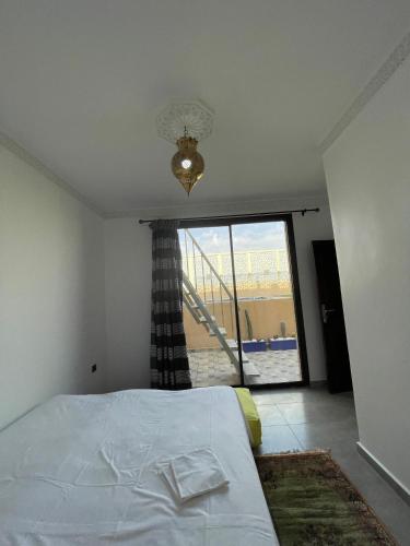 a bedroom with a bed and a large window at Diaft'na in Marrakech