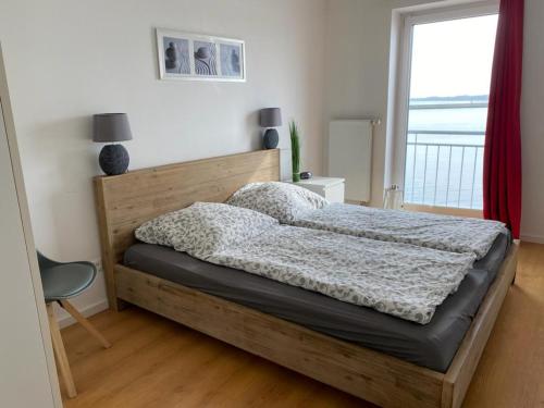 a bedroom with a bed with a wooden frame and a window at Ferienhaus Wellenreiter in Kappeln