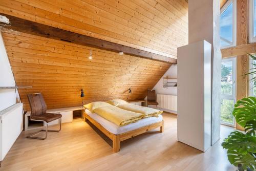 a bedroom with a bed and a wooden ceiling at Ferienwohnung Rabus in Bisingen