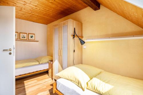 a bedroom with two beds and a wooden ceiling at Ferienwohnung Rabus in Bisingen
