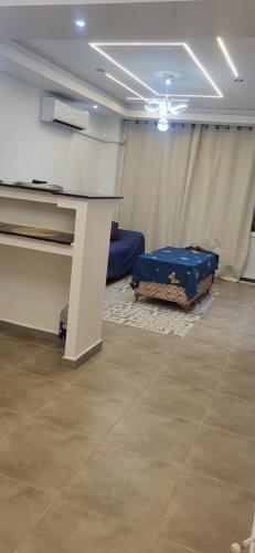 a room with a table and a blue suitcase on the floor at Bel oranger in Bejaïa