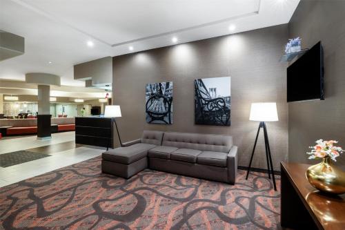 a living room with a couch and a television at Best Western Premier NYC Gateway Hotel in North Bergen