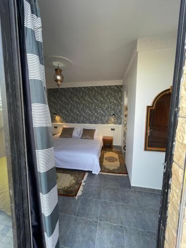 a bedroom with a white bed in a room at Diaft'na in Marrakech