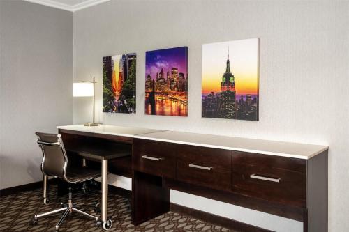 a desk in a hotel room with paintings on the wall at Best Western Premier NYC Gateway Hotel in North Bergen