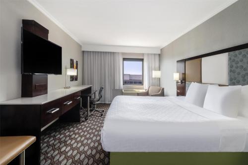 a hotel room with a large bed and a desk at Best Western Premier NYC Gateway Hotel in North Bergen