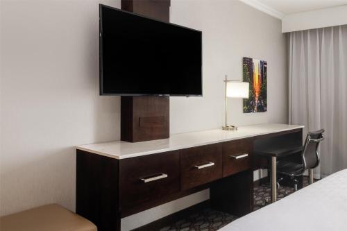 a hotel room with a desk with a television on it at Best Western Premier NYC Gateway Hotel in North Bergen