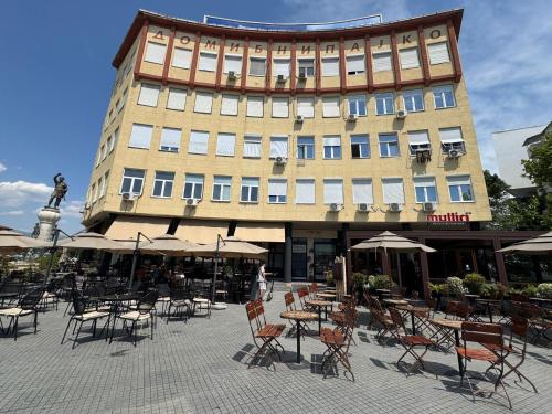 um grande edifício com mesas e cadeiras em frente em Stone Bridge Studio em Skopje