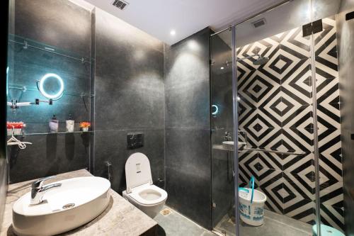 a bathroom with a toilet and a glass shower at Galaxy blue sapphire plaza in Ghaziabad