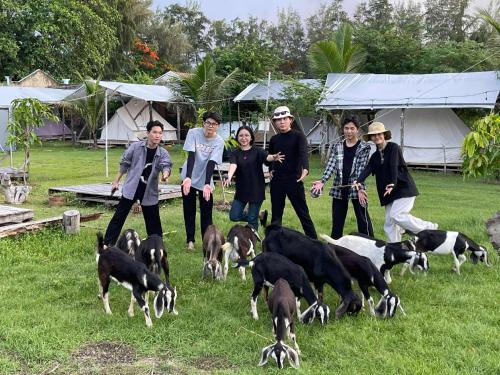 a group of people with dogs in a field at Eco Beach Can GIo in Kon Rung (1)