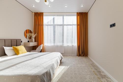 TaldykolʼにあるАпартаменты, в которые хочется возвращатьсяの大きなベッドと窓のある寝室