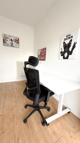 a white desk with a black chair in a room at Benmey Apartment Küche,TV,Waschmaschine in MHG