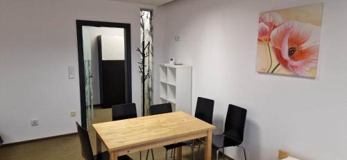 une salle à manger avec une table en bois et des chaises noires dans l'établissement Żołnierska Hostel, à Leszno