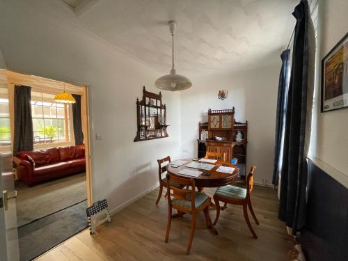 a dining room with a table and chairs and a couch at The Old Station, Station House, Snettisham Norfolk in Snettisham