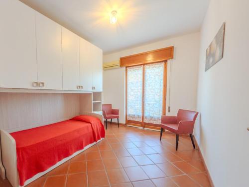 a bedroom with a red bed and two chairs at La Casa di Dario - Super Luminosa - 5' dal mare in Albinia