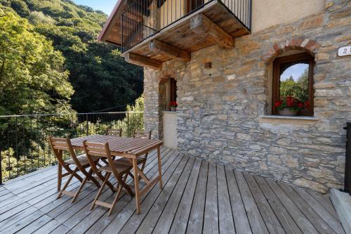 a wooden deck with a table and chairs on it at Lo Sarvanot in Bernezzo