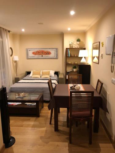 a bedroom with a bed and a table and a dining room at Centrica Suite de Lujo Parking Incluido in Vigo