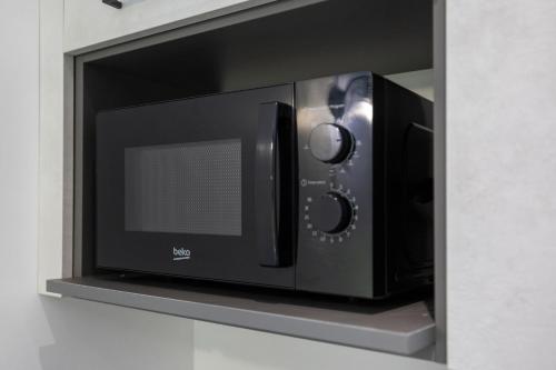 a microwave oven sitting on a shelf in a kitchen at Lo Sarvanot in Bernezzo