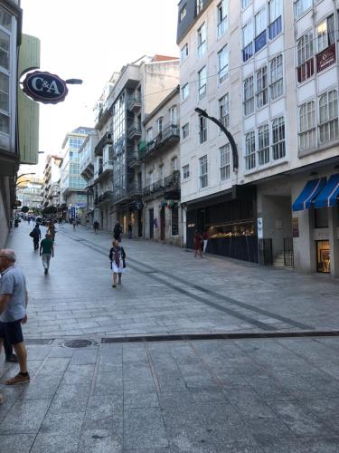 a little girl walking down a city street with buildings at Centrica Suite de Lujo Parking Incluido in Vigo