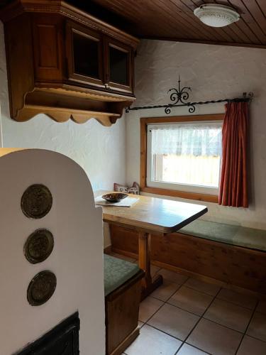 a kitchen with a wooden table and a window at mansarda rustica in Padola