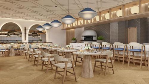 a restaurant with white tables and chairs and blue lights at Secrets Mirabel Cancún Resort & Spa in Cancún