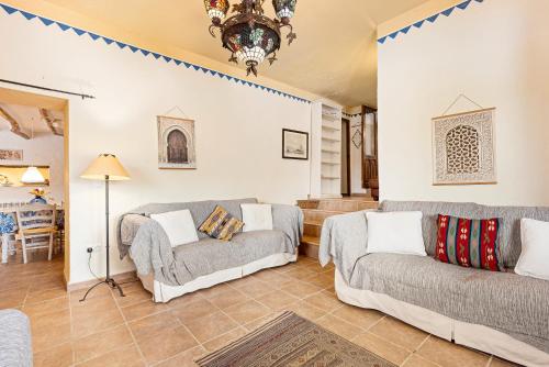 ein Wohnzimmer mit zwei Sofas und einem Tisch in der Unterkunft Casa rural Furones in Villanueva de Algaidas