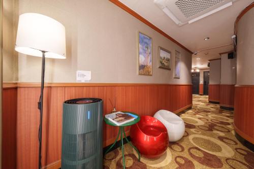 a hallway with a lamp and a table and a stool at Bongrae Motel in Incheon