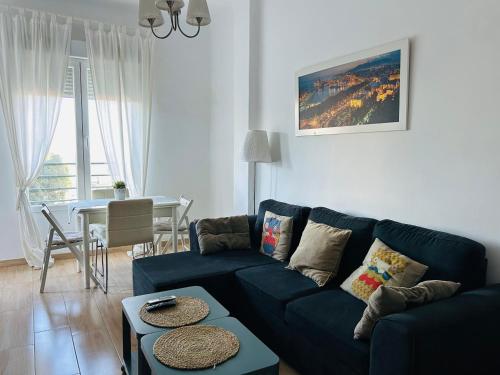 a living room with a blue couch and a table at Solymar Beach Premium in Málaga