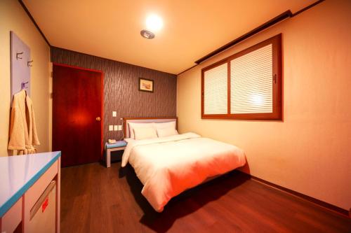 a bedroom with a bed and a window in it at Bongrae Motel in Incheon