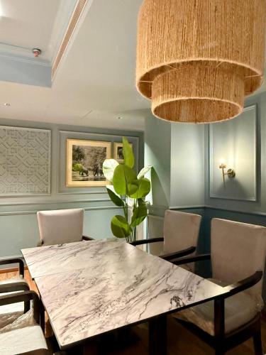 a dining room with a marble table and chairs at Hotel O2 VIP in Kolkata